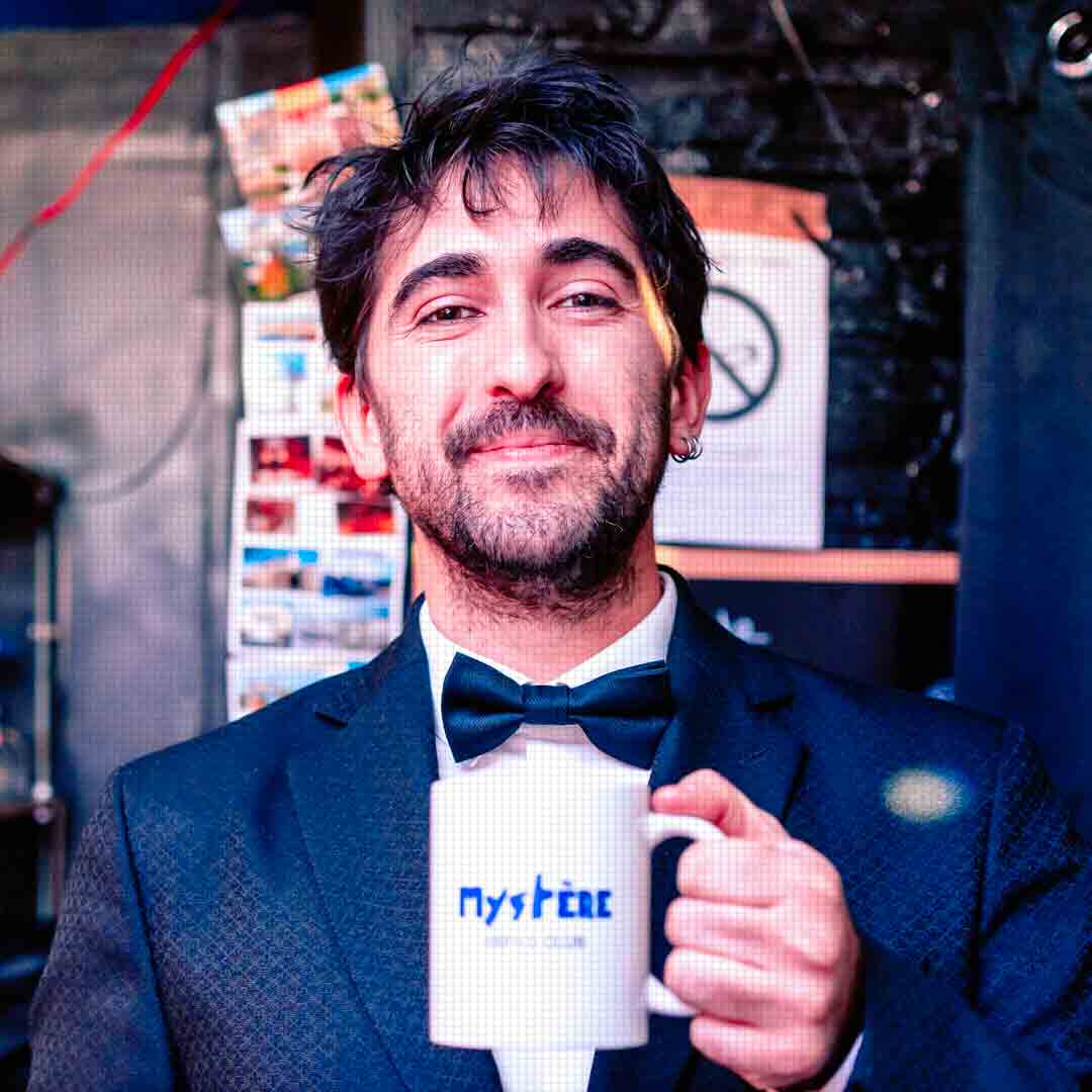 Un comédien du Mystère Impro Club avec un mug de la maison
